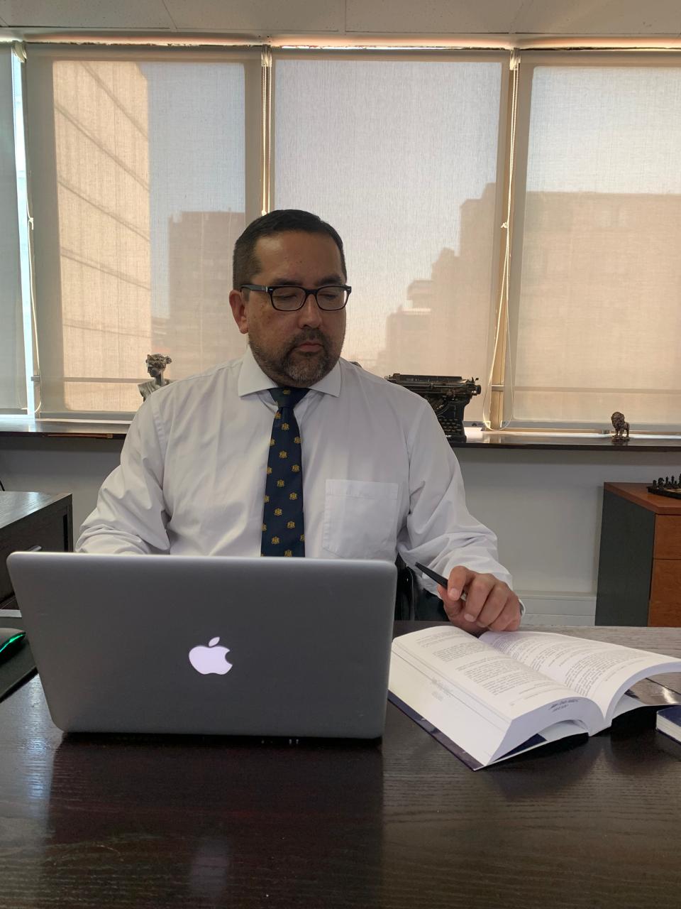 Abogado Juan Carlos en su oficina en Santiago asesorando a cliente deudor